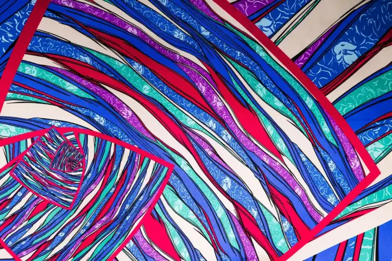 Abstract collage of colorful folded fabric ribbons in shades of blue, pink, purple, and teal.