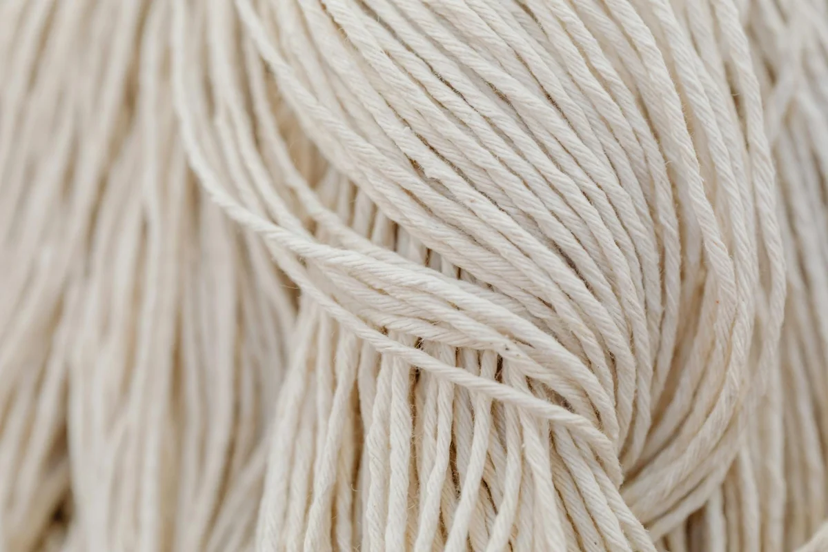 Close-up image of natural beige alpaca fiber strands with soft, twisted texture