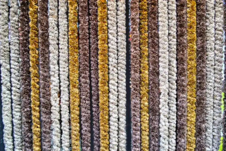 Close-up view of vertical textured basketweave shirting samples in neutral and earthy tones such as brown, beige, grey, and mustard.