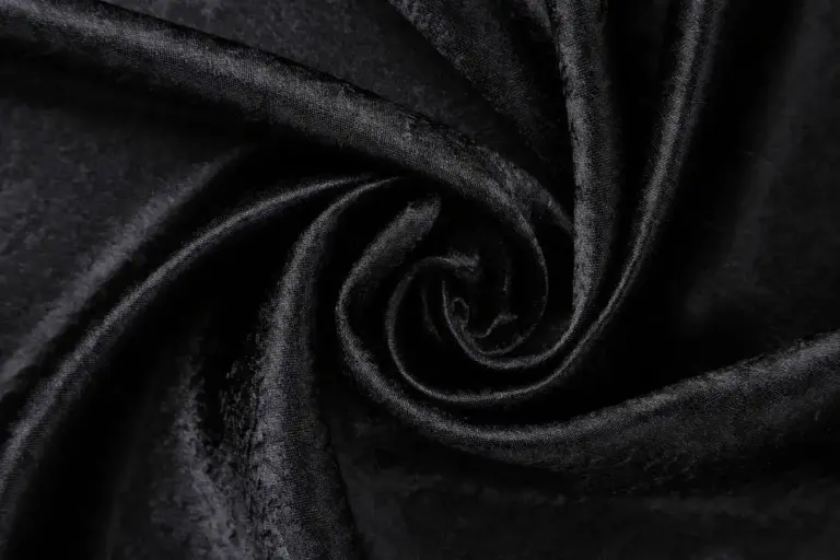 Close-up image of black velvet fabric twisted into a swirling pattern.
