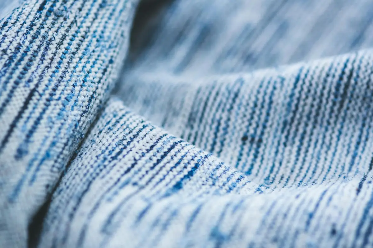 Close-up of blue and white striped woven fabric with visible fibers and texture