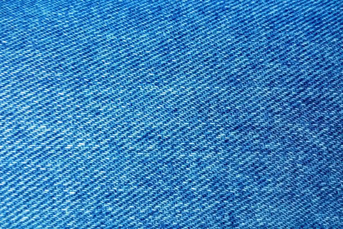 Close-up of blue denim fabric showing a diagonal weave pattern
