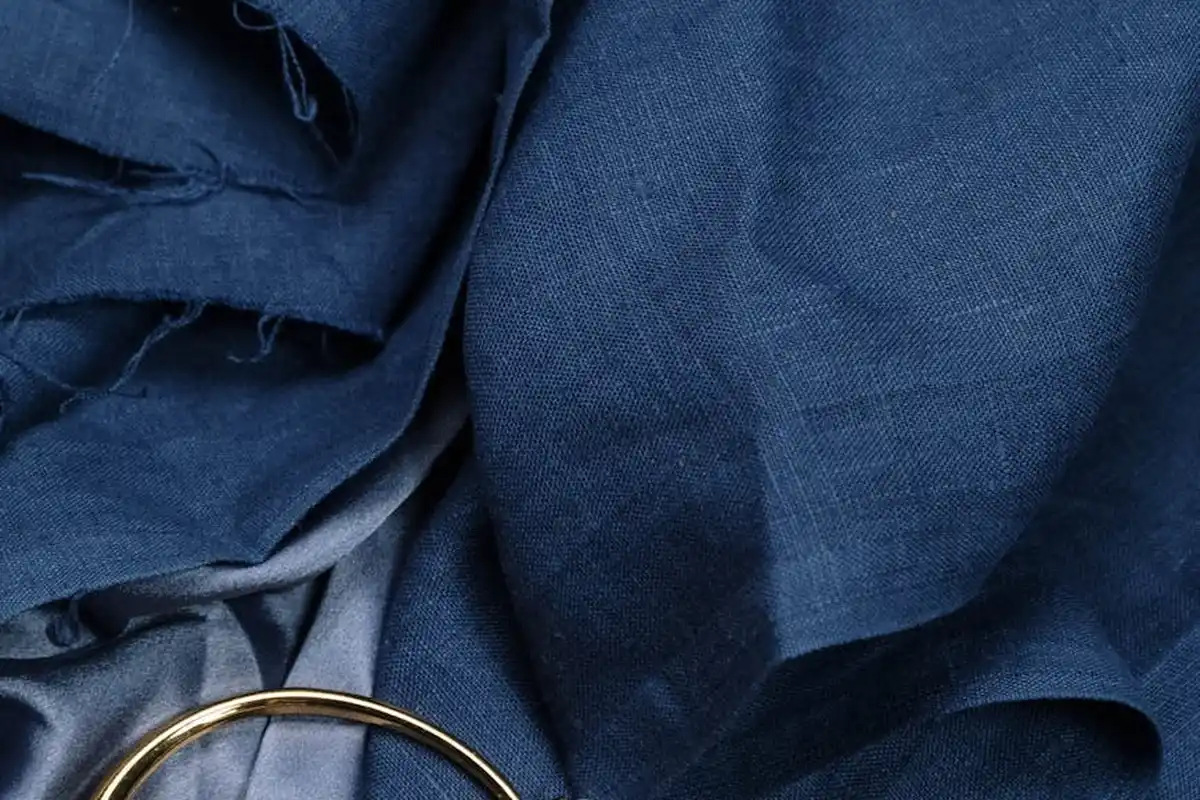 Close-up of blue fabric draped with a gold ring