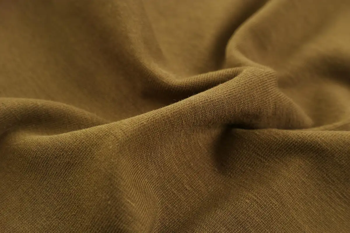 Close-up of brown modal stretch fabric with soft folds and wrinkles