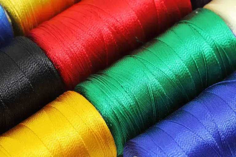 Close-up of bright nylon thread spools in yellow, red, green, blue and black.