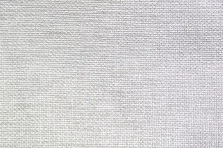 Close-up of woven white cotton fabric showing its texture.