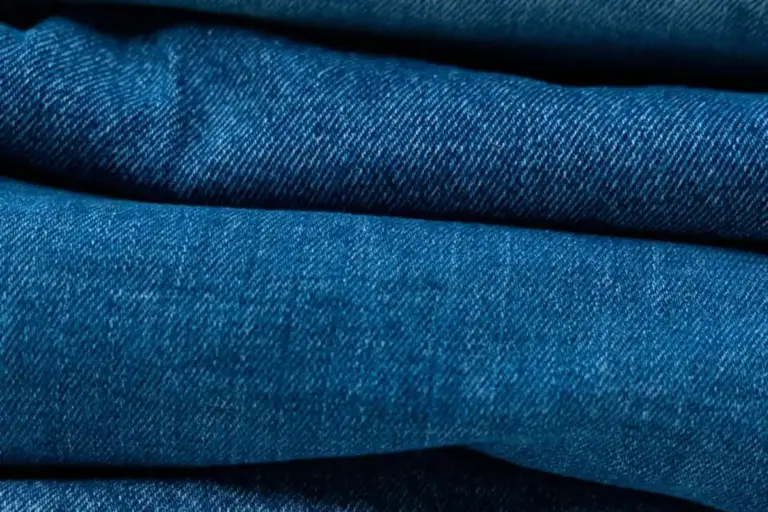 Close-up of blue denim fabric showing weave and folds.