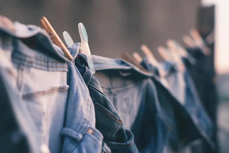 Denim jeans hanging on a clothesline with clothespins.