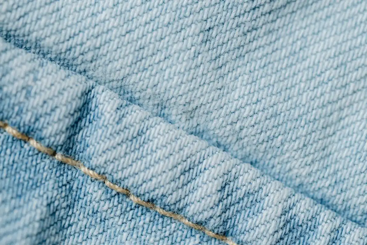 Close-up of blue denim fabric weave with a stitched seam