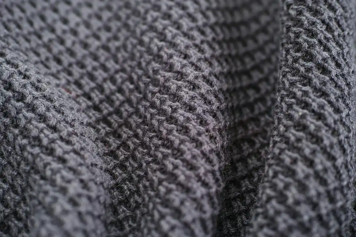 Macro close-up of dark gray woven fabric showing textured fibers