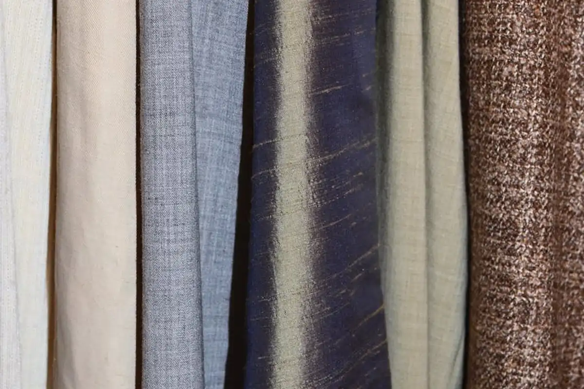Rows of fabric rolls in neutral and earthy tones hanging side by side.
