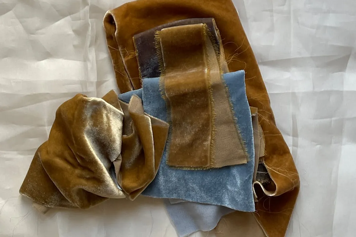 Multiple fabric swatches in brown, blue, and tan hues arranged on a white background to illustrate at-home dye tests.
