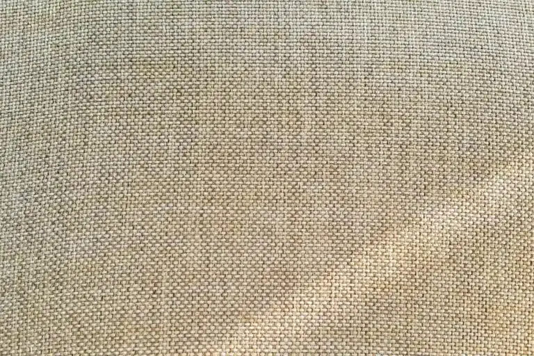 Close-up of woven beige fabric texture with visible fibers
