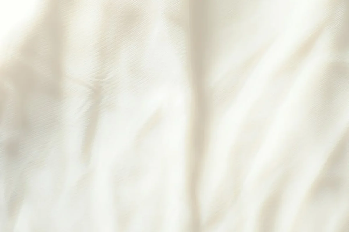 Close-up of soft, off-white flannel fabric with subtle folds and a smooth nap