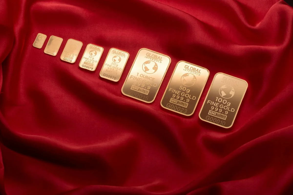 Gold bullion bars laid out on red satin fabric