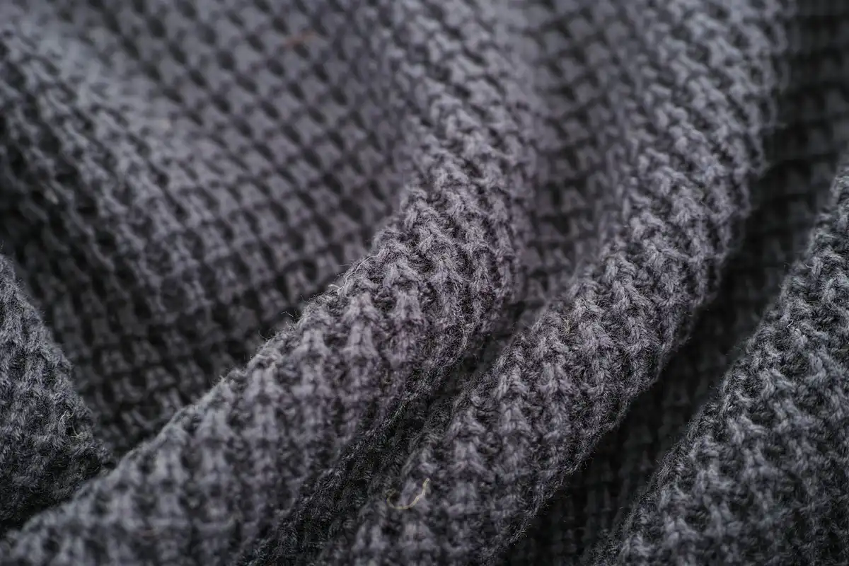 Close-up of textured gray woven fabric with visible interlacing fibers