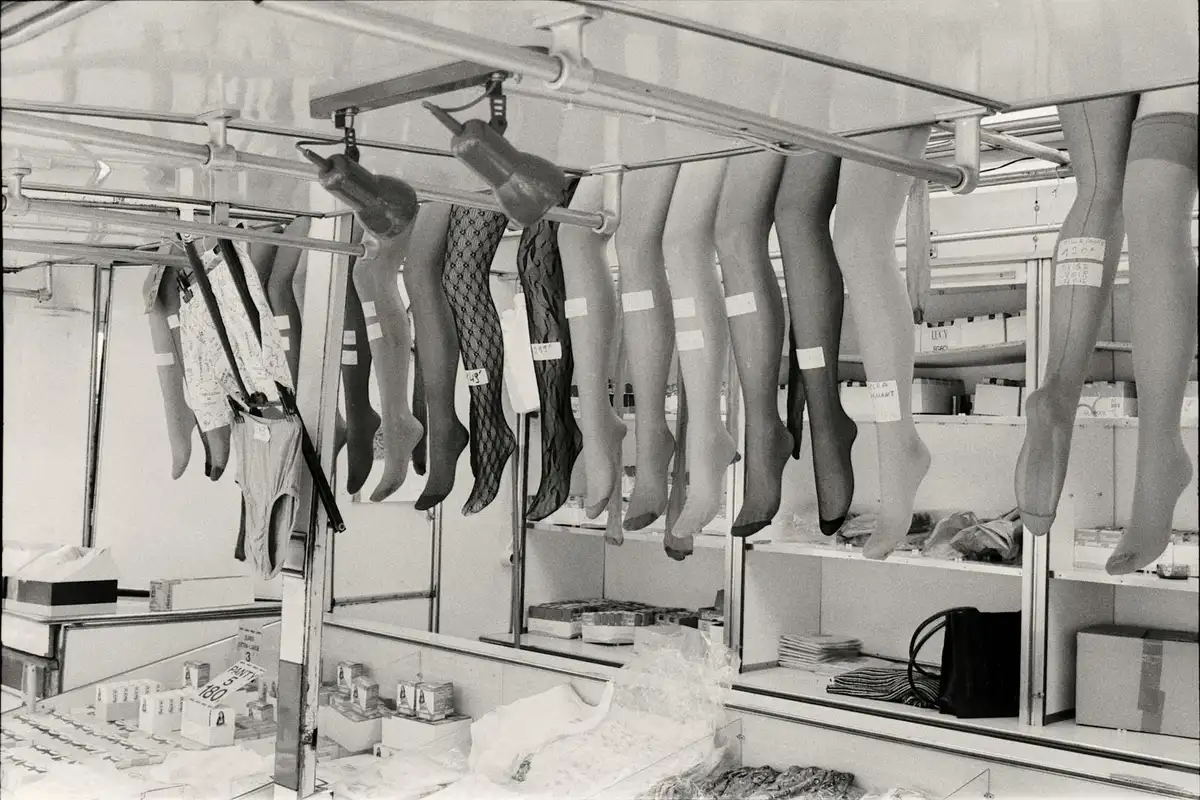 Rows of tights and stockings hanging from drying rails in a factory, illustrating stretched fabric and potential sagging.