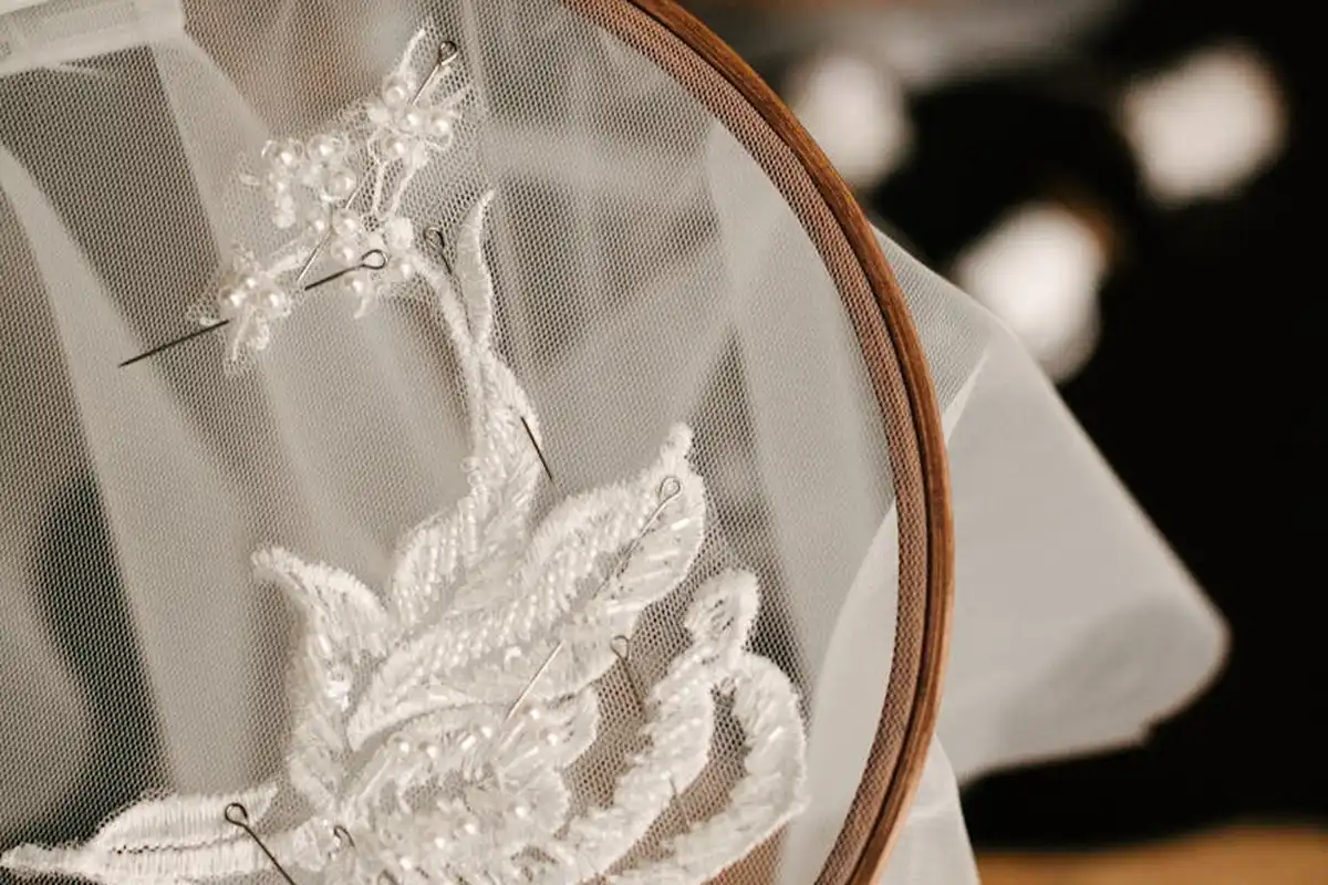 Close-up of white lace fabric mounted in a wooden embroidery hoop