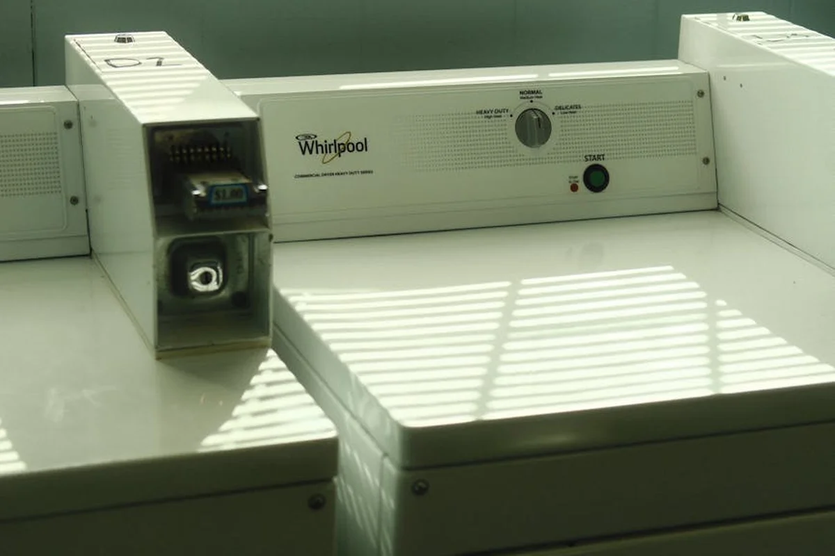 Close-up of a white Whirlpool washing machine control panel in a laundry room.
