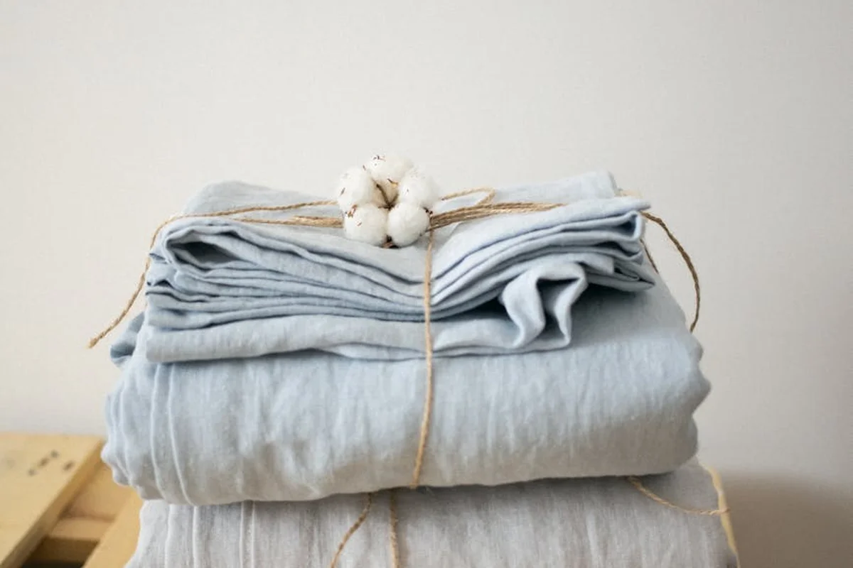 Light blue folded linen fabric stacked and tied with string, ready for air drying.