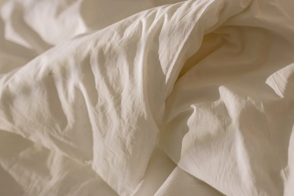 Close-up of soft, wrinkled ivory linen fabric