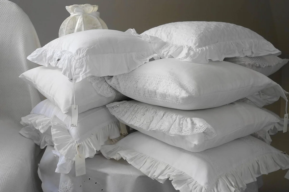 Stack of white pillows with tags in a linen mill workshop