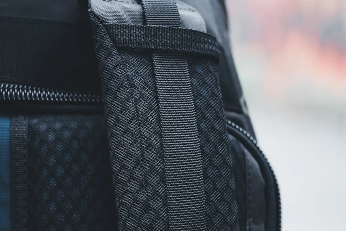 Close-up of a black nylon backpack strap with a zipper