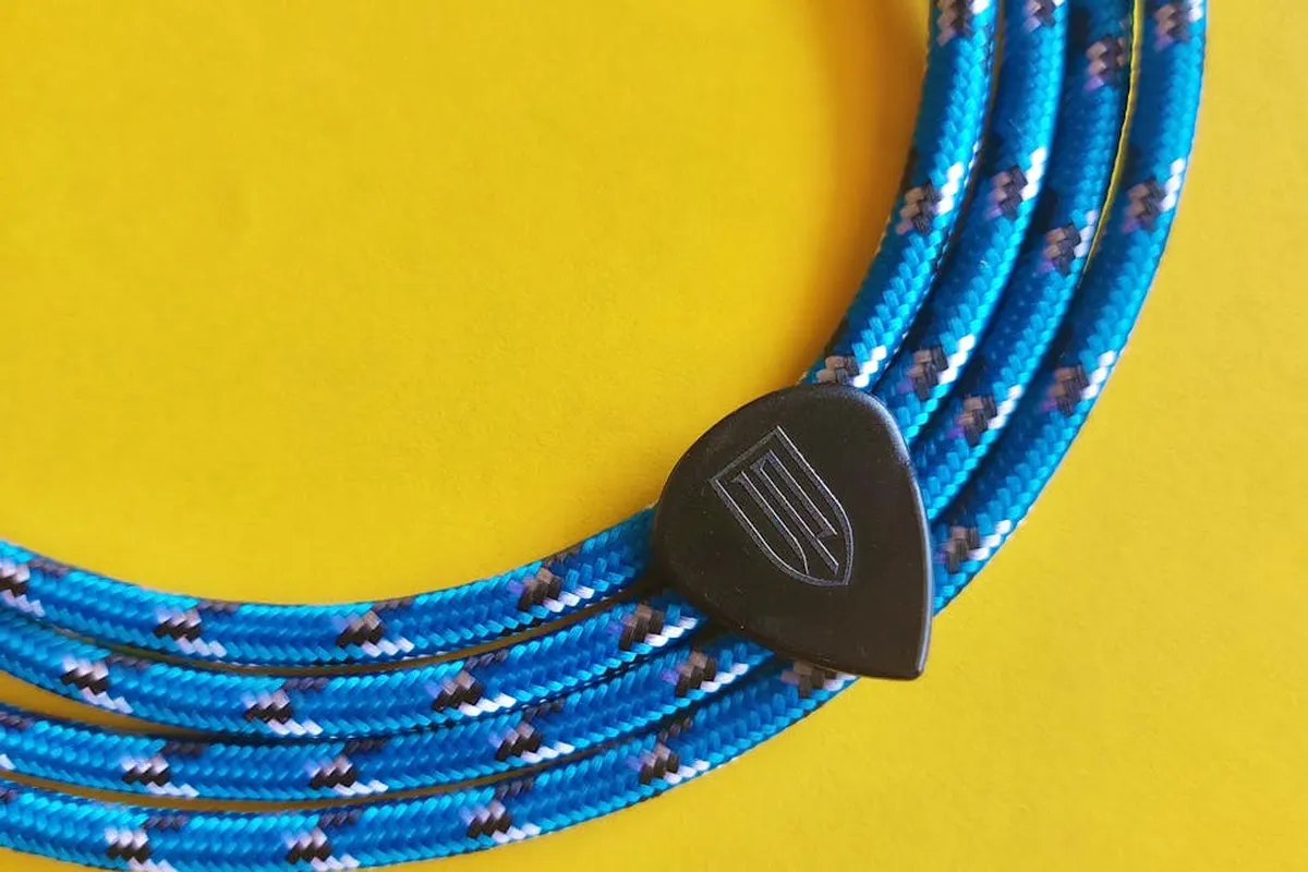 Blue nylon rope with a black plastic toggle against a yellow background.
