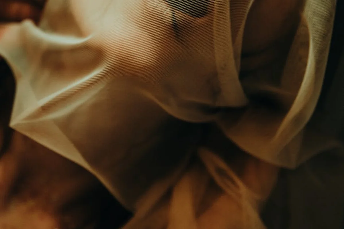 Close-up of sheer amber-toned nylon-spandex fabric with soft folds and texture