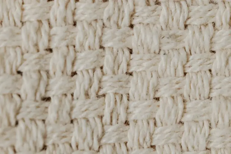Close-up of beige woven nylon fabric showing interlaced fibers and a grid-like texture.