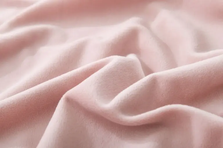 Soft pink flannel fabric close-up with folds