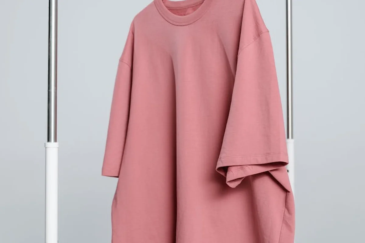 Loose-fitting pink viscose-blend top hanging on a clothing rack