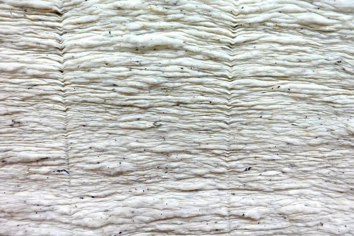 Close-up of a wrinkled, textured polyester fabric with horizontal ridges