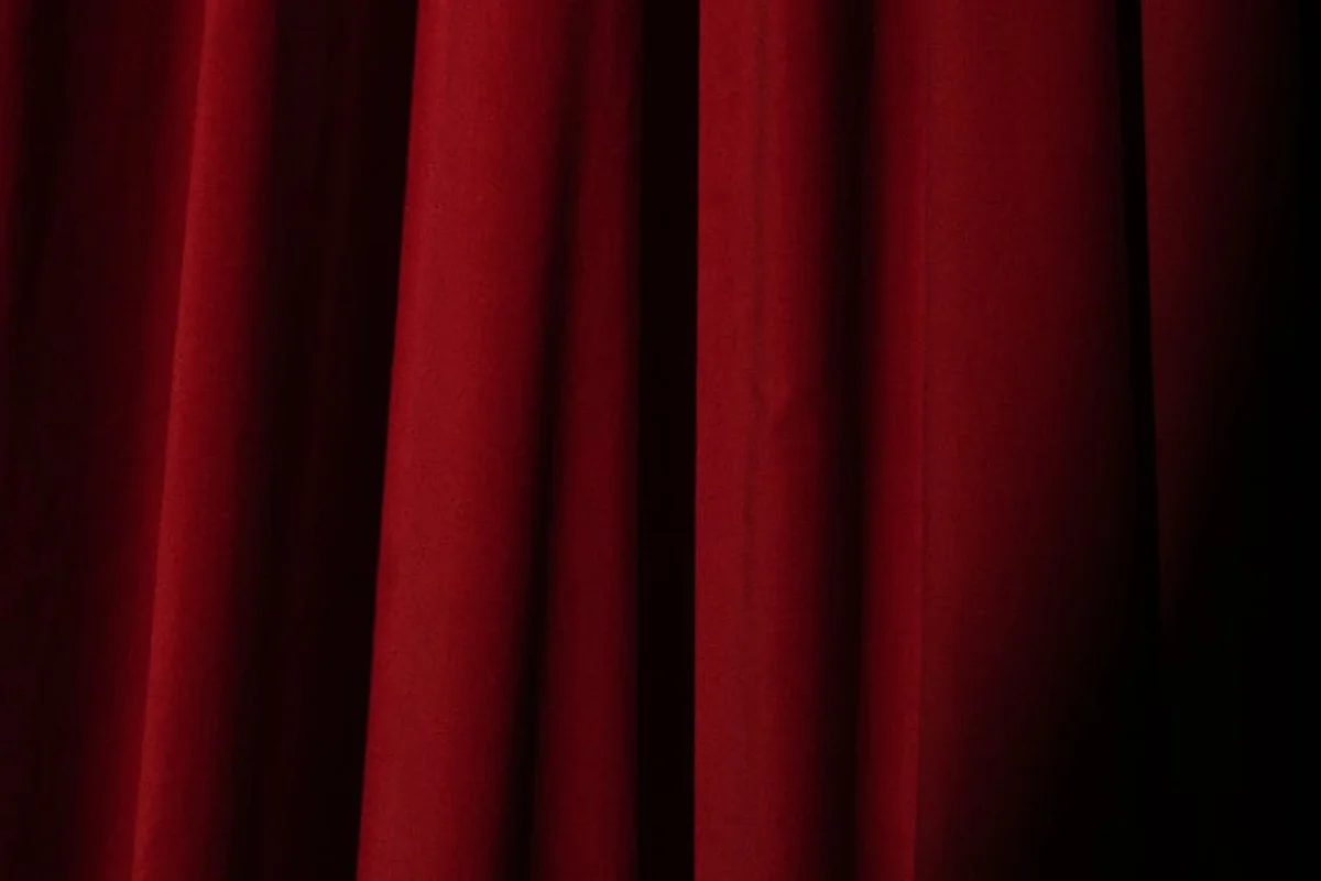 Close-up of rich red velvet drapery with deep folds and soft shadows