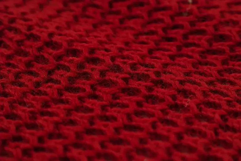 Close-up view of red woven wool fabric texture.