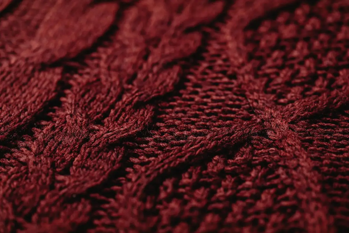 Close-up of textured red fabric from volleyball spandex apparel, showing a knit pattern.