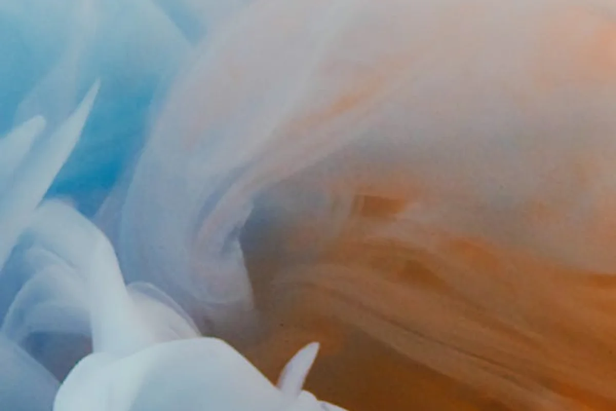 Abstract swirls of blue and orange dye representing dyeing stretchy fabrics like spandex