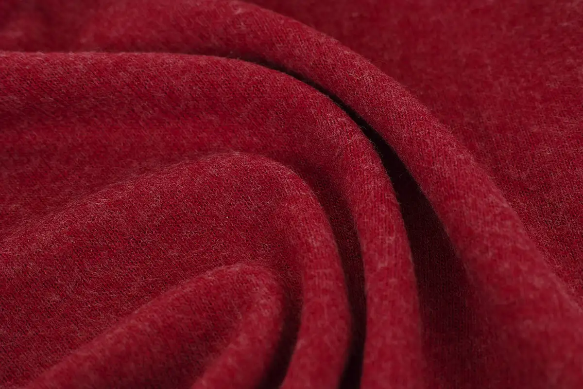 Close-up of deep red silk fabric with soft folds and a subtle sheen.