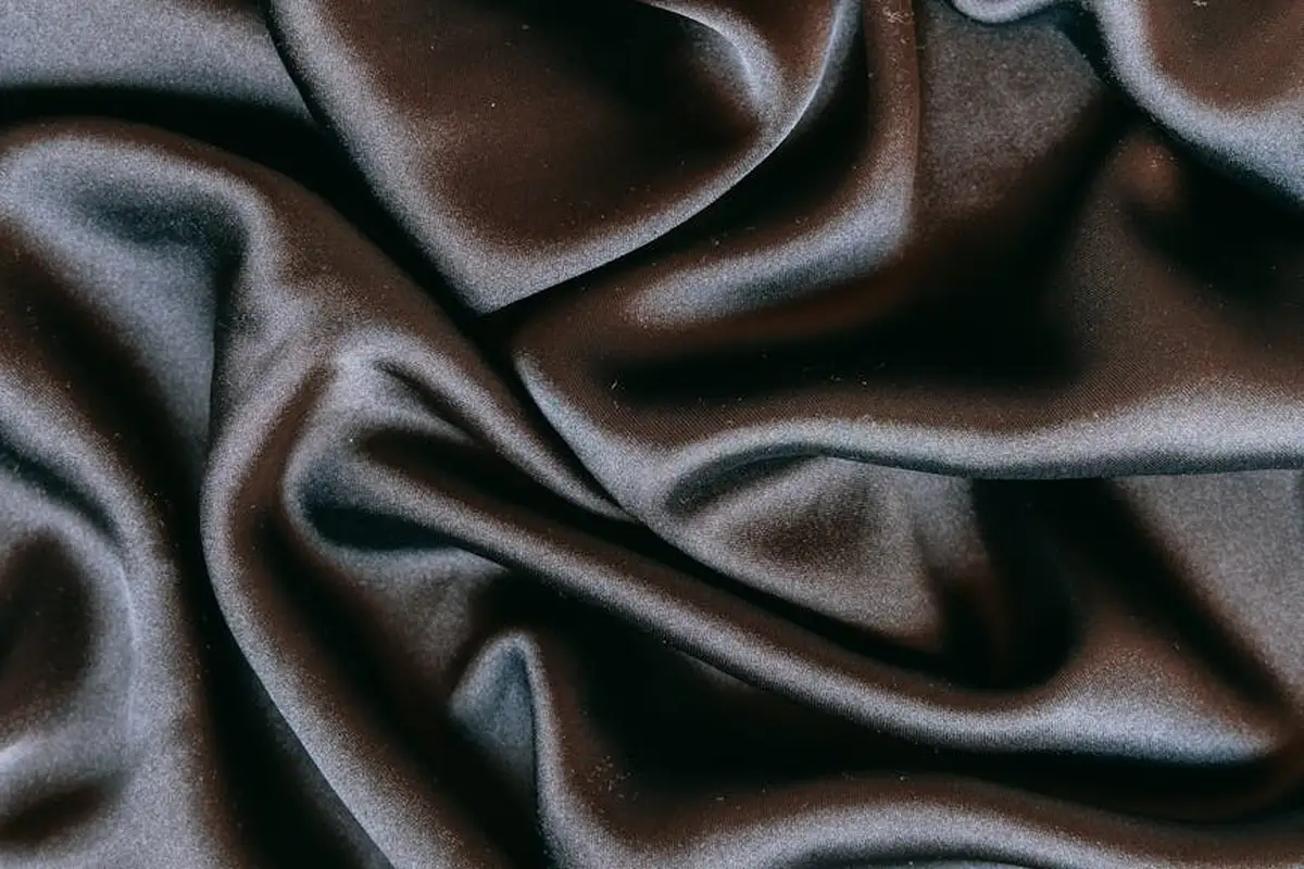 Close-up of brown satin fabric with smooth folds