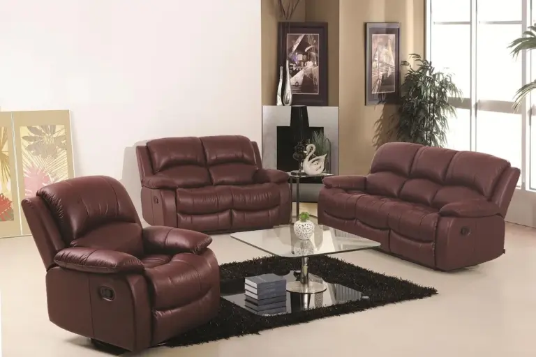 Showroom with burgundy upholstered seating, including a recliner and two sofas, arranged around a glass coffee table on a black rug.