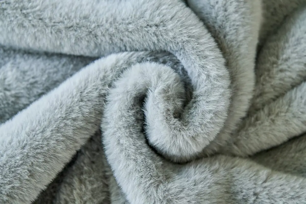 Close-up of soft, plush gray fabric texture with folded fibers