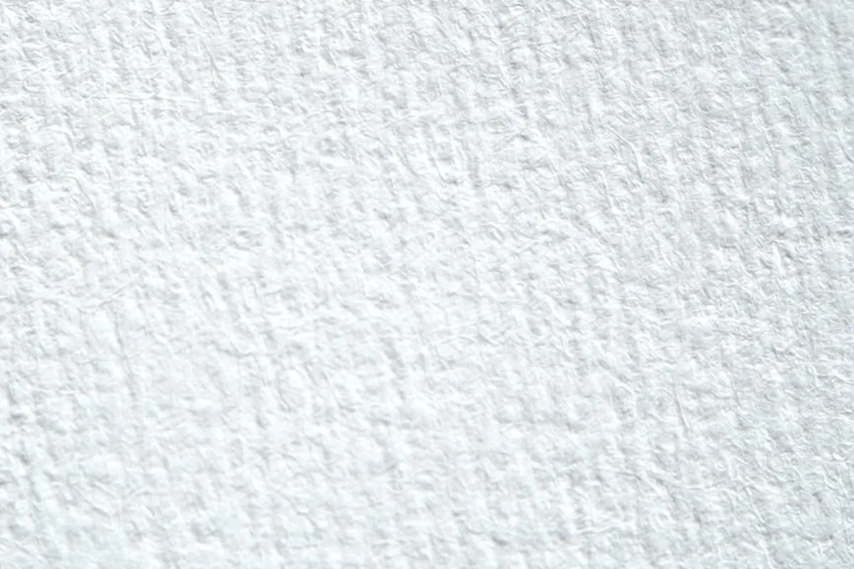 Close-up of white, textured fabric surface with subtle creases