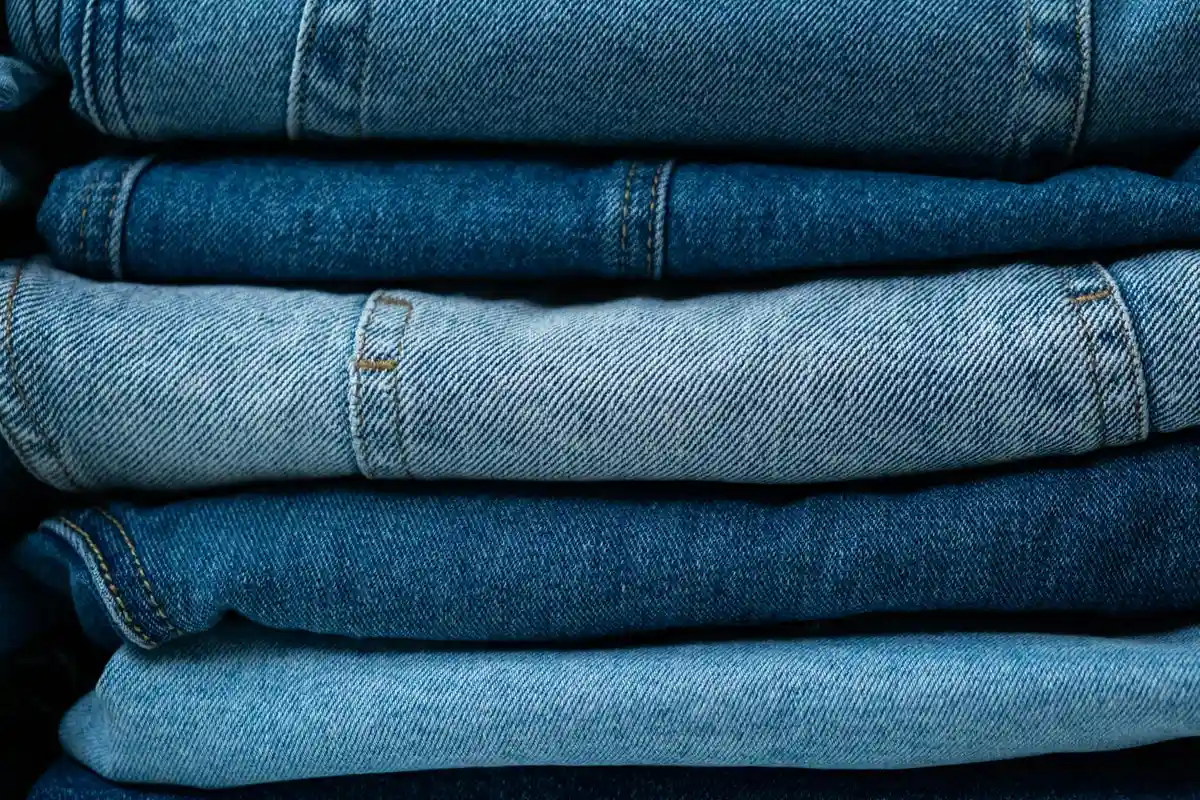 Stacked folded blue denim fabric showing varied weaves and textures