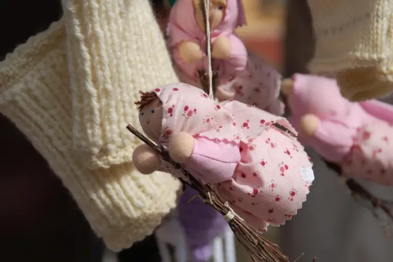 Close-up of cream knitted fabric and pink floral fabric pieces with twigs, illustrating stretch fabric textures and elasticity