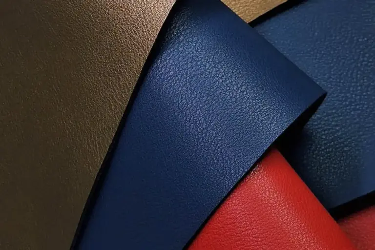 Close-up of overlapping faux leather swatches in blue, navy, and red
