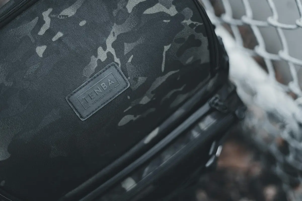 Close-up of a black camouflage nylon bag featuring a Tenba patch
