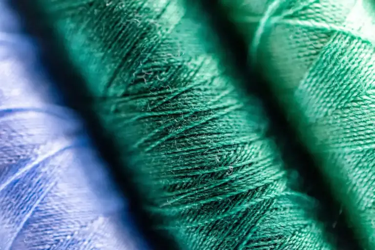 Macro image of blue, teal, and green sewing threads