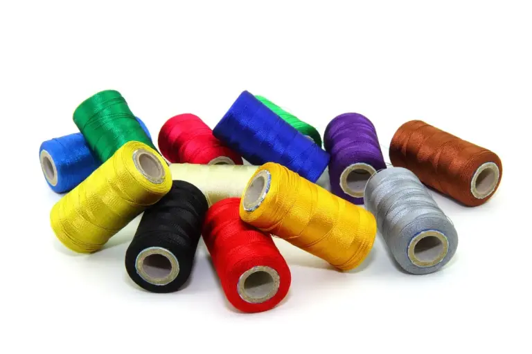 Assorted bright-colored thread spools on a white background