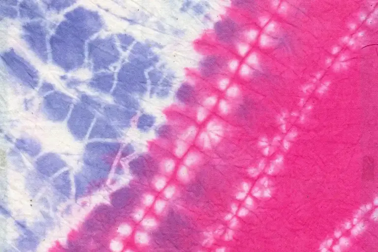 Close-up of pink and purple tie-dye fabric with white crackle lines.