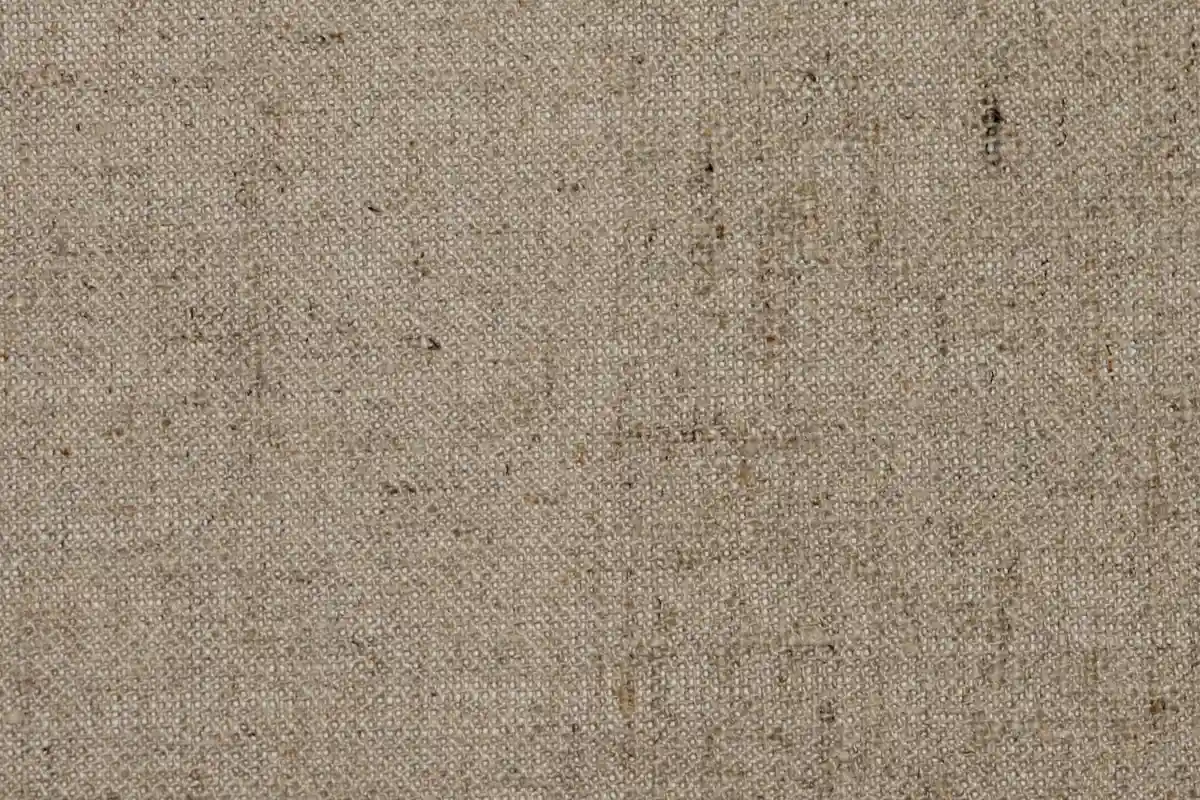 Close-up of a beige woven fabric texture, illustrating viscose fabric as a subject for care instructions.